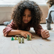 Load image into Gallery viewer, Child playing with colorful wooden pieces on a wooden floor