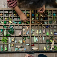 Load image into Gallery viewer, Person arranging small decorative items in a vintage wooden box on a wooden surface