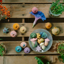 Load image into Gallery viewer, Colorful soap bars on a wooden surface with plants and flowers.