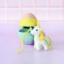 Load image into Gallery viewer, Small white unicorn toy with a yellow mane and tail, standing on a light purple surface with a pink tiled wall background.