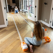Load image into Gallery viewer, Two children playing with toy air blower on a wooden floor.