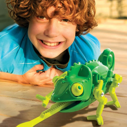 Child playing with a green toy lizard on a wooden surface