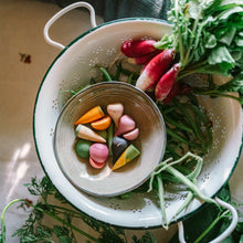 Load image into Gallery viewer, Colander with vegetables and a bowl of colorful candies on a table.
