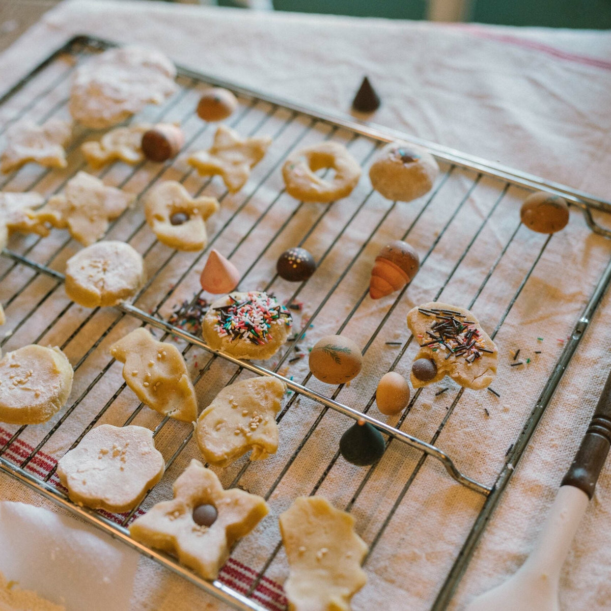 Decorative cookies on a cooling rack with a flour-dusted surface