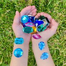 Load image into Gallery viewer, Hands holding colorful gemstone toys on grass
