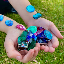Load image into Gallery viewer, Hands holding colorful gemstone toys on grass
