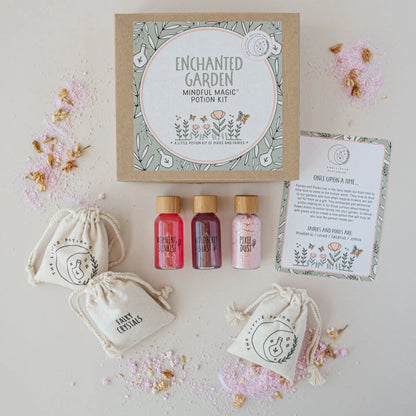 Set of small bottles, bags, and a circular product with 'Enchanted Garden' branding on a light background.