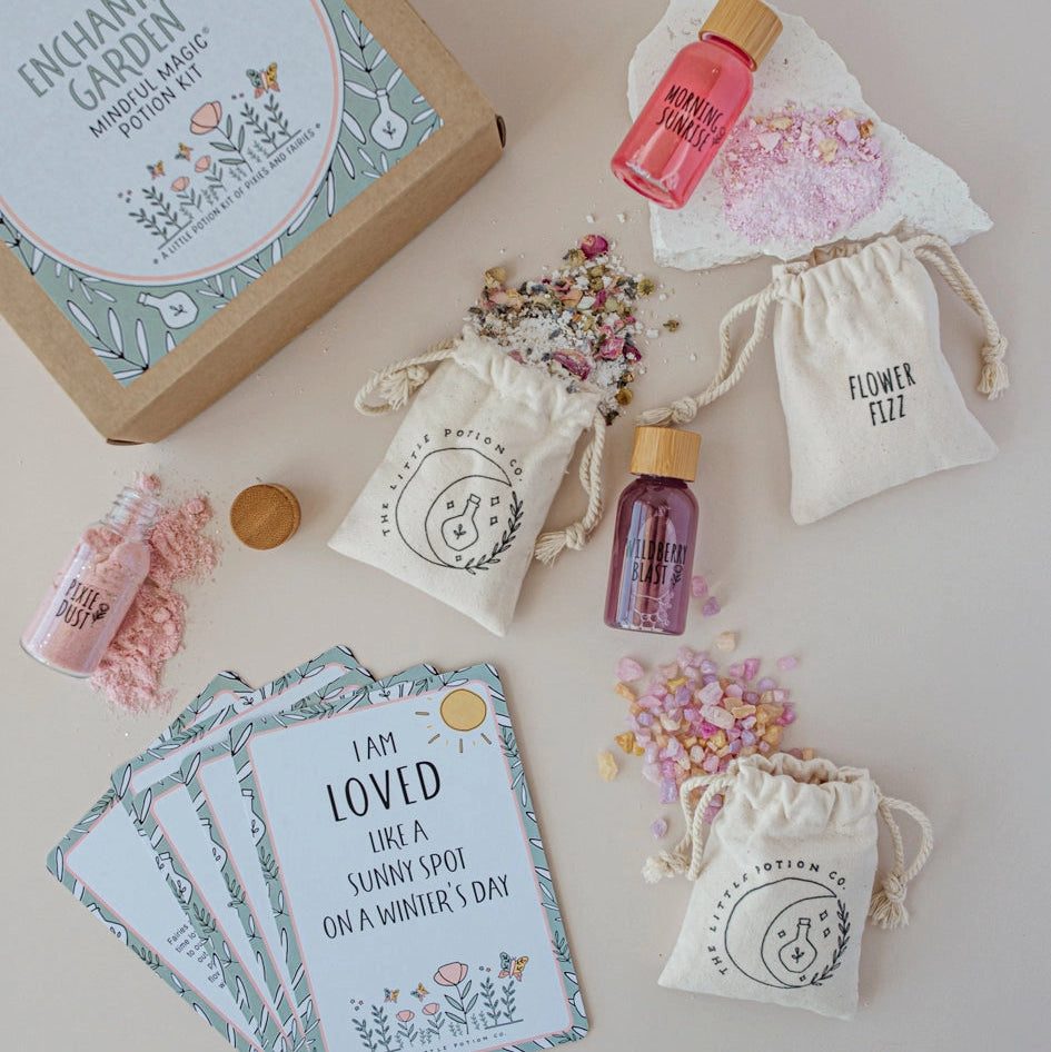 Enchanted Garden magic potion kit with bottles, cards, and drawstring bags on a light background