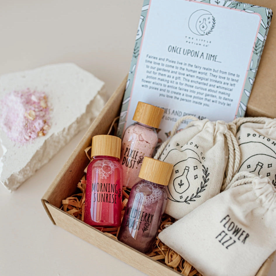 Gift set with bottles, a pouch, and a card in a box on a light background