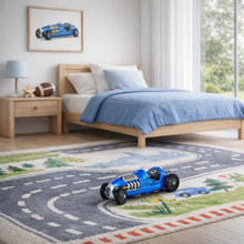 Load image into Gallery viewer, Children's bedroom with a bed, nightstand, and toy car on a rug.
