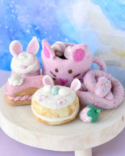 Load image into Gallery viewer, Plush toys shaped like donuts with animal ears on a marble surface.
