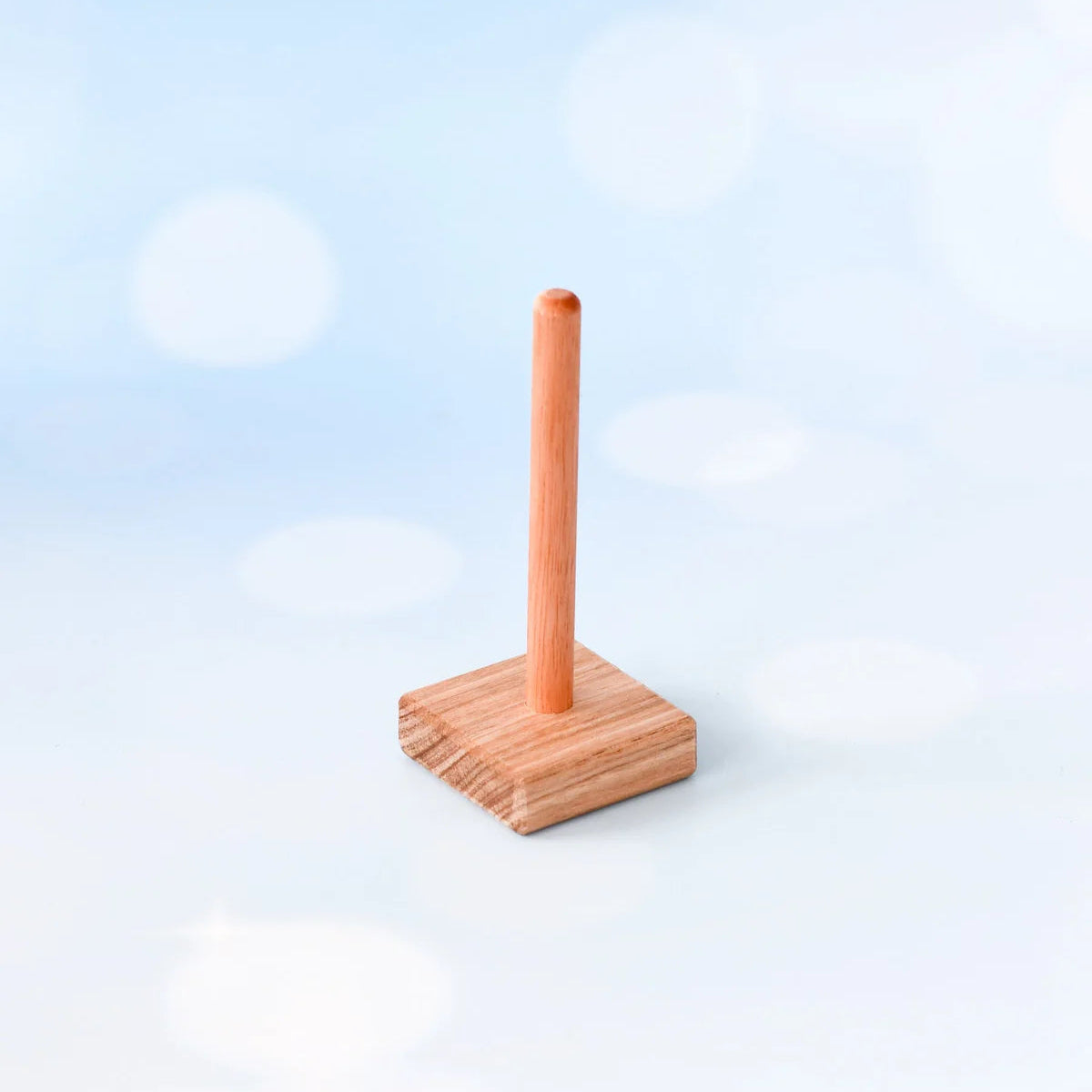 Wooden paper towel holder on a light blue background