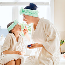 Load image into Gallery viewer, Woman and child in bathrobes with headbands, sitting together in a bathroom.
