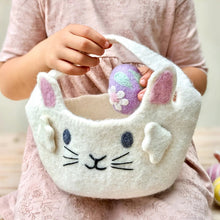 Load image into Gallery viewer, Child holding a white bunny-shaped basket with a purple Easter egg inside, wearing a pink shirt.
